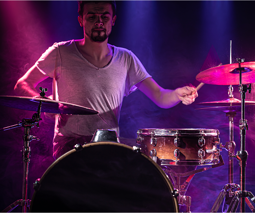Drummer playing in purple light
