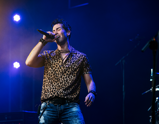 Singer on stage in a leopard print shirt