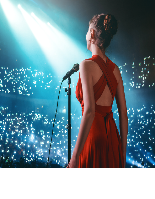 Singer in a red dress facing a crowd